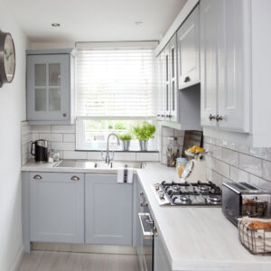 Compact L-Shaped Kitchen Cabinets in light gray with subway tile backsplash and modern appliances