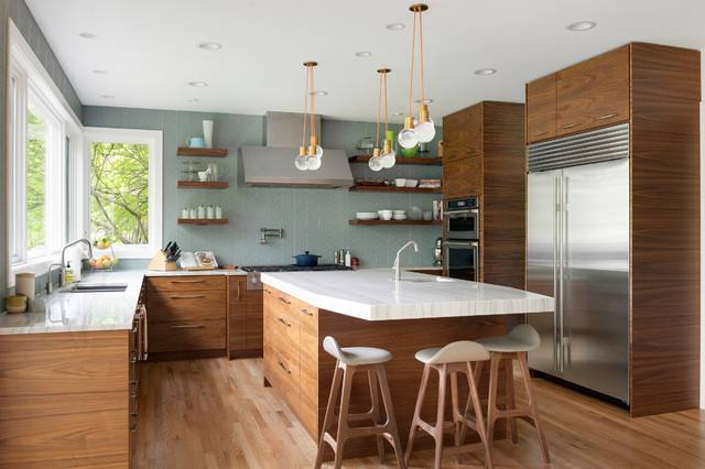 Modern kitchen with walnut wood cabinets, white countertop island, and stainless steel appliances creating a warm and elegant family space