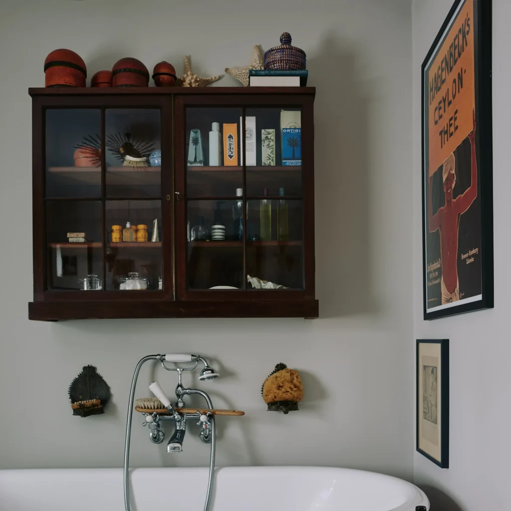 Vintage bathroom cabinet with dark wood frame and mullion glass door above a bathtub