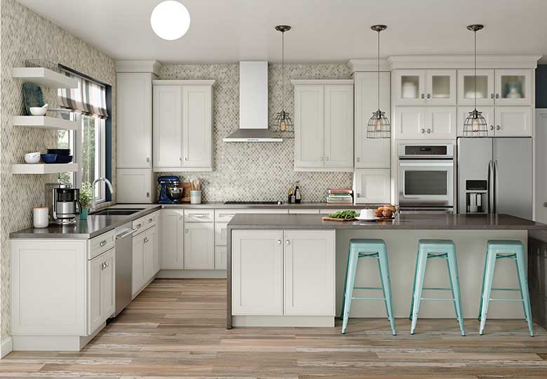 U-shaped kitchen with white Shaker kitchen cabinets, gray island, stainless steel appliances, mosaic backsplash, and teal bar stools