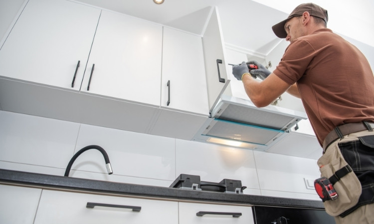 Technician repairing RTA Cabinets in a modern Canadian kitchen – easy cabinet repair and replacement