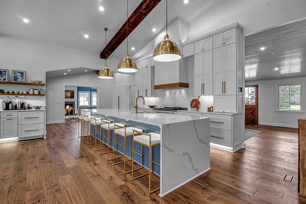 Modern Canadian kitchen with white shaker RTA cabinets, large island, quartz countertops, and gold pendant lighting – premium multi-unit design