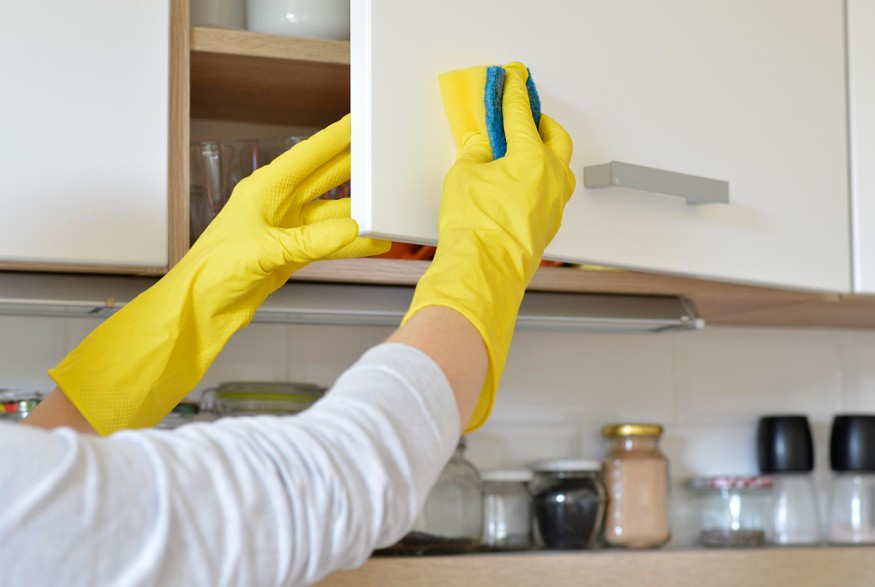 Homeowner cleaning modern RTA kitchen cabinets in Canada, showing durability, easy maintenance, and cost-saving design