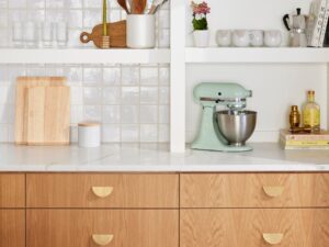 Modern kitchen with engineered wood cabinets and a reflective Backsplash Glass tile wall – Canada design inspiration