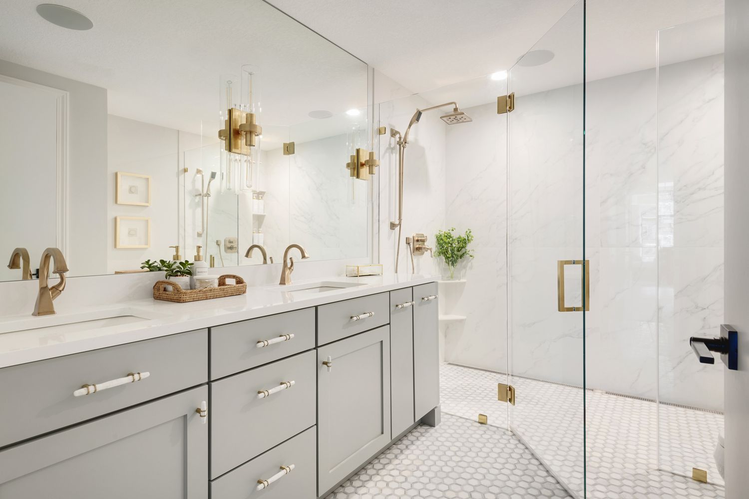 Modern bathroom with gray double vanities, quartz countertop, gold hardware, and glass walk-in shower in Mississauga home