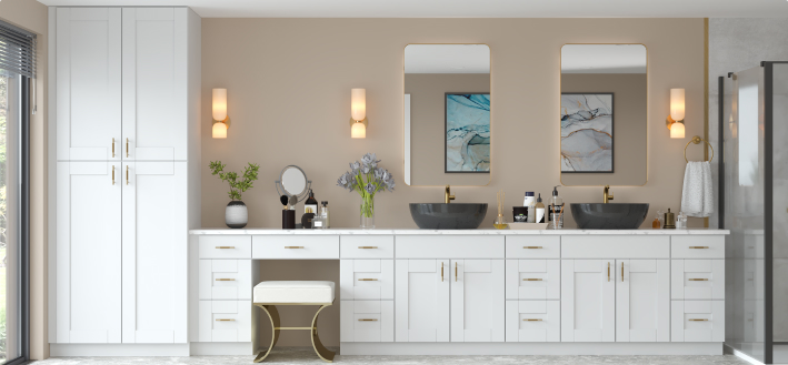 Kitchen & Bathroom Cabinets – airy white kitchen with gray shaker cabinets, quartz peninsula, glass uppers, stainless hood, and indoor plants.