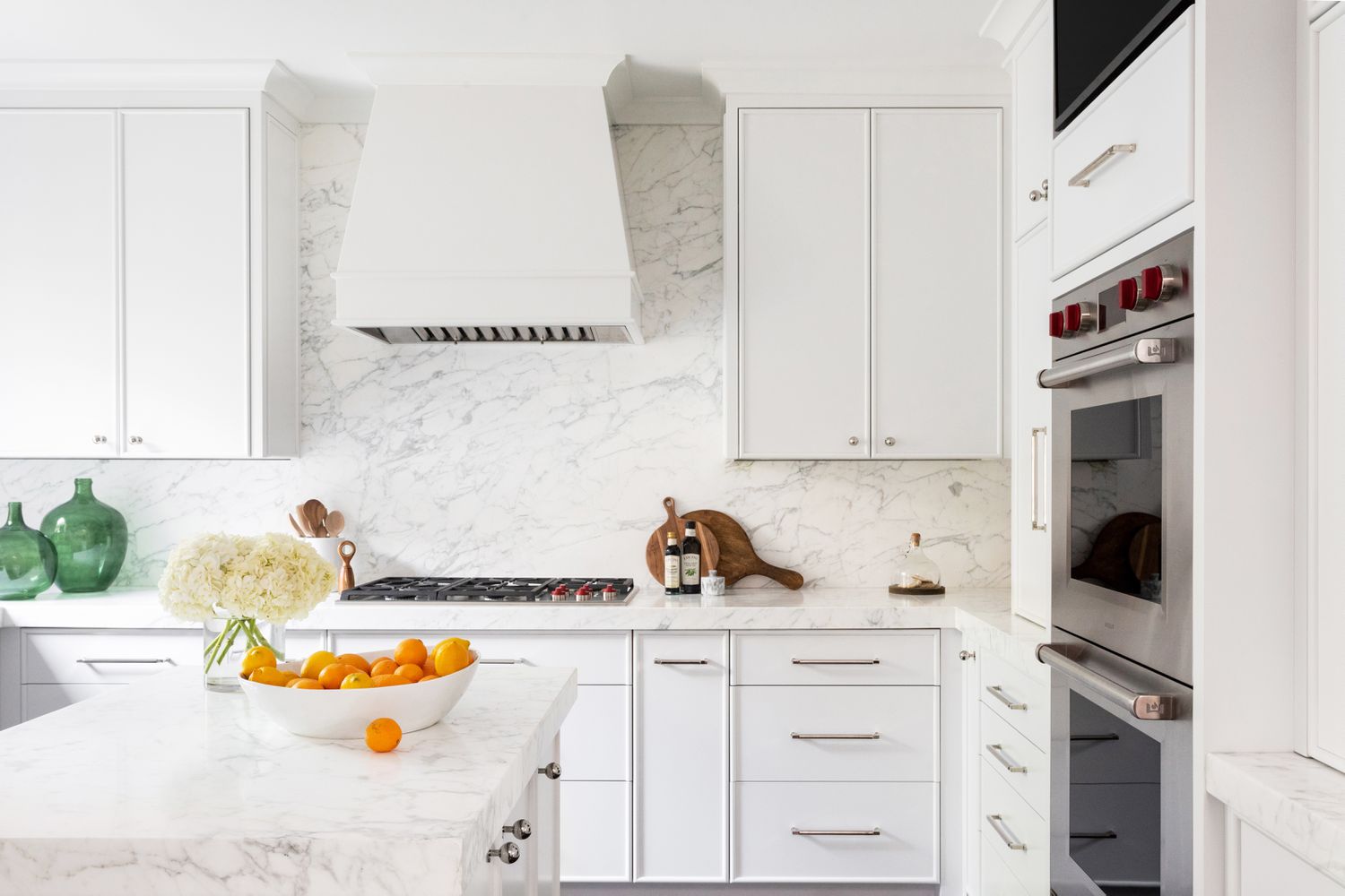 Bright Canadian kitchen featuring the best kitchen cabinet colors Canada—sleek all-white cabinetry with chrome handles, marble countertops, and a matching marble backsplash for a timeless luxury look.