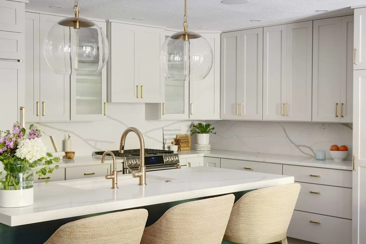 Modern Canadian kitchen with light beige shaker cabinets, gold hardware, and white quartz countertops — best kitchen cabinet colors Canada.