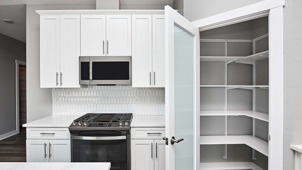 Premium RTA cabinets Canada – modern white kitchen with built-in microwave, gas range, and open pantry shelving