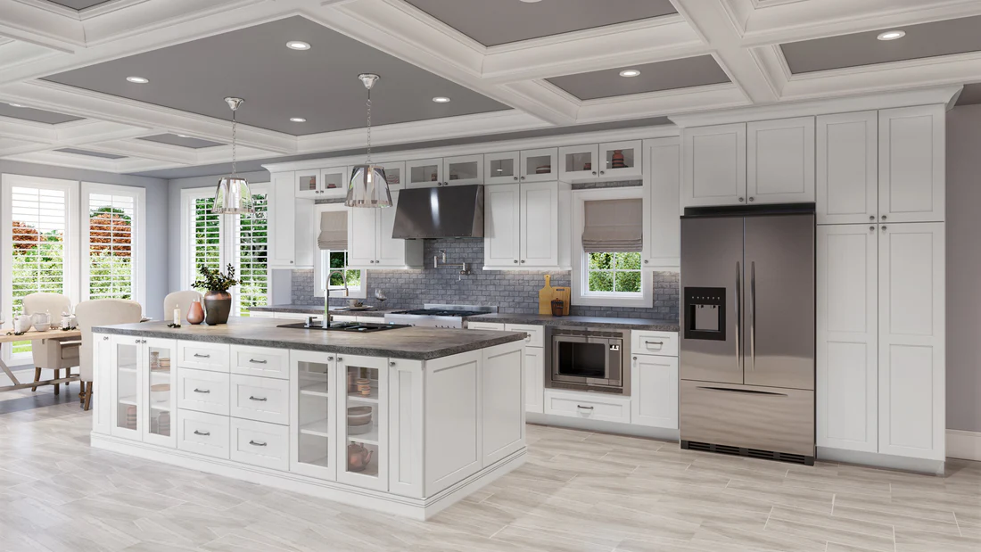 Luxury white kitchen with premium RTA cabinets Canada—shaker doors, glass-front uppers, gray quartz island, and stainless appliances beneath a coffered ceiling.