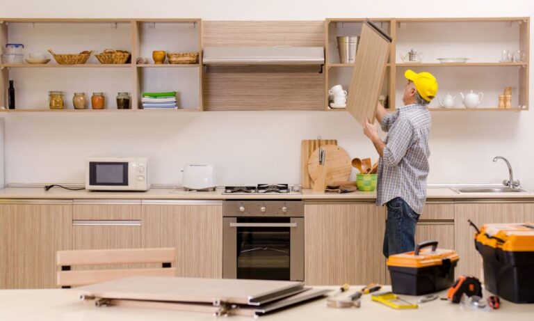 RTA cabinet installation in Canada—installer fitting a wall cabinet door in a modern kitchen, showing tools for leveling on uneven floors and walls
