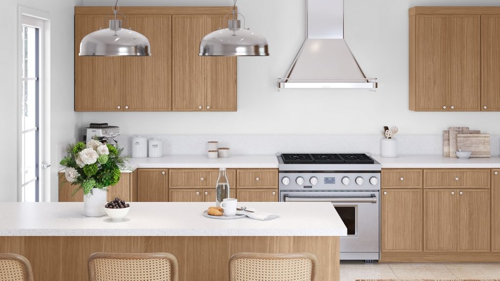 Minimalist kitchen with light wood shaker cabinets, white quartz countertops, large island, stainless range and hood, and metal dome pendants — premium RTA cabinets Canada.