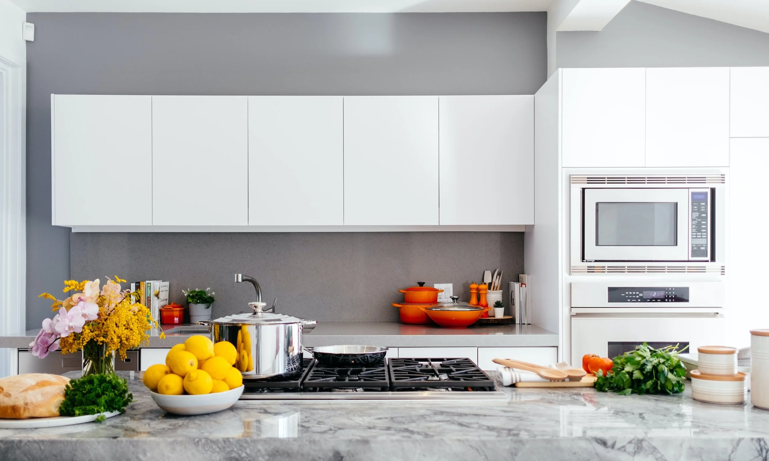 Modern Canadian kitchen featuring sleek white cabinets, gray backsplash, and marble countertops — a perfect example of the best kitchen cabinet colors in Canada for bright, spacious home design.