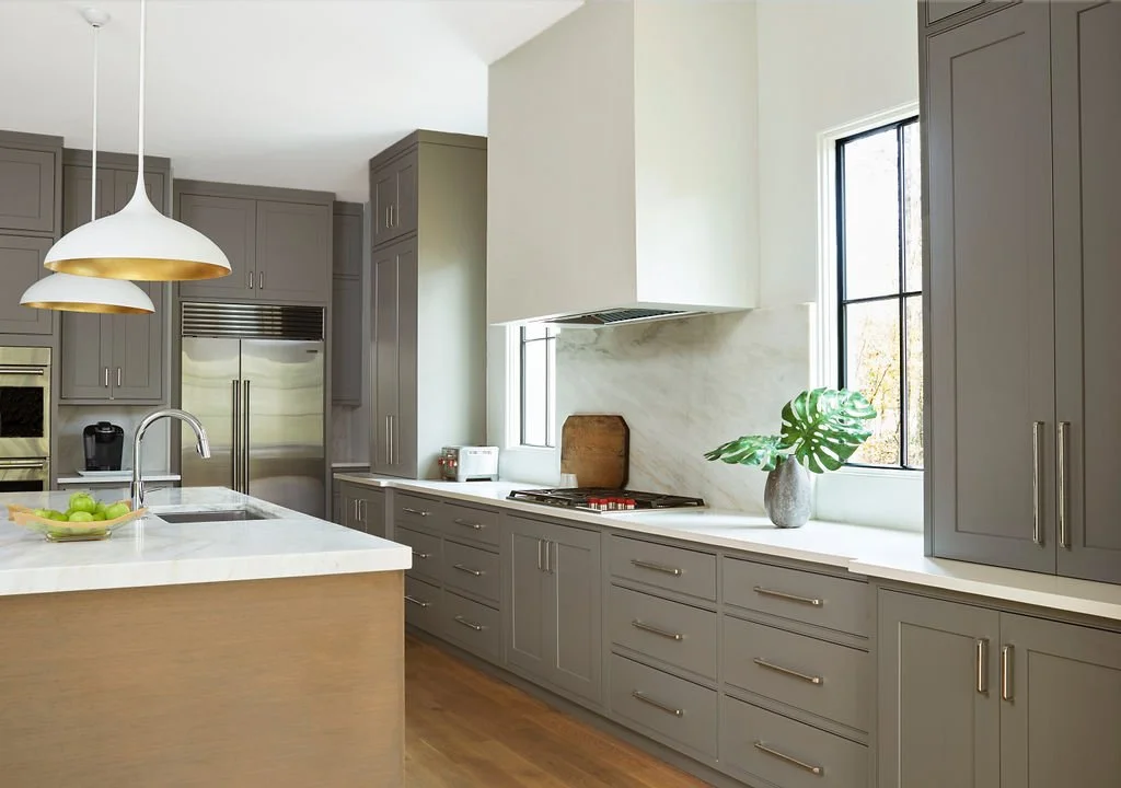 Modern Canadian kitchen cabinet design with gray floor-to-ceiling shaker cabinets, white quartz countertops, and brass pendant lights