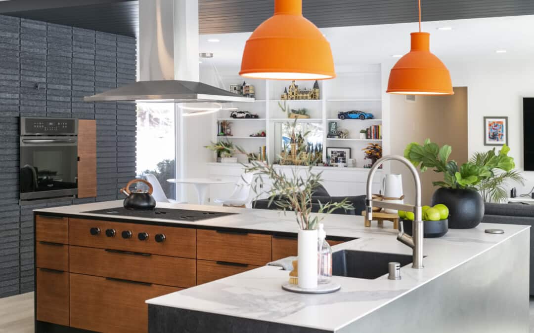 Eco-friendly, low-VOC kitchen cabinets in Canada — modern wood cabinetry with a white-quartz island, stainless hood, and orange pendant lights
