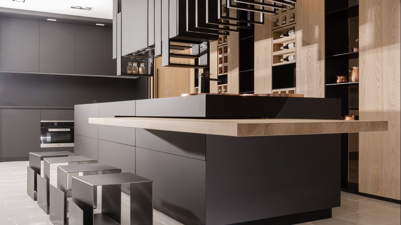 Ultra-modern black kitchen cabinet design with matte flat panels, light wood accents, and integrated wine storage around a large island with metal stools.
