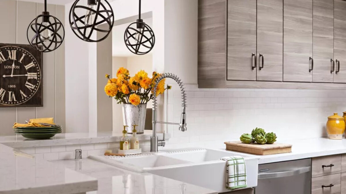 Contemporary kitchen with wood-grain flat-panel kitchen cabinets, white quartz counters, white subway tile backsplash, globe pendant lights, and a spring pull-down faucet over a double sink.