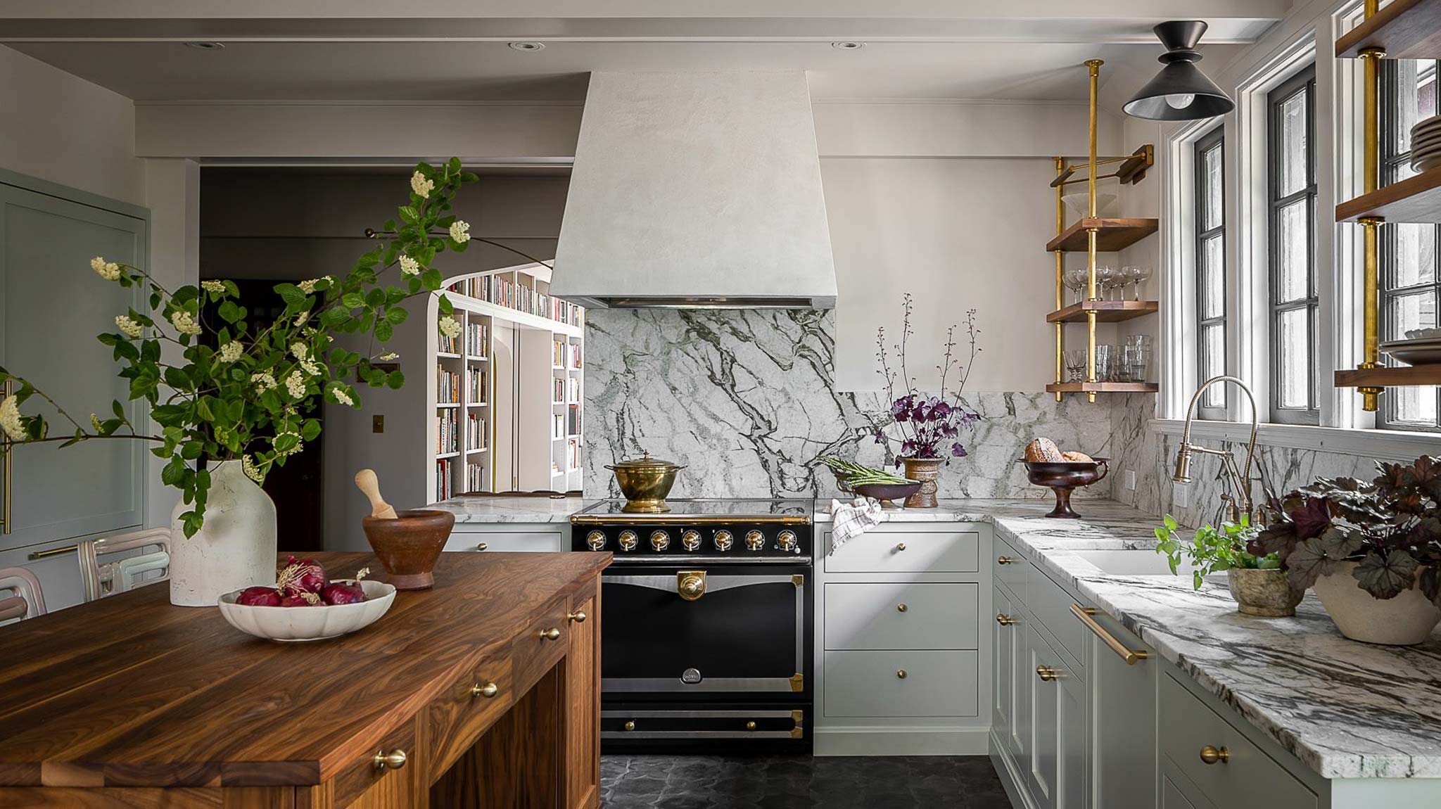 Modern kitchen with sage-gray shaker cabinets, brass hardware, and dramatic marble backsplash—low price kitchen cabinet inspiration with a high-end look.