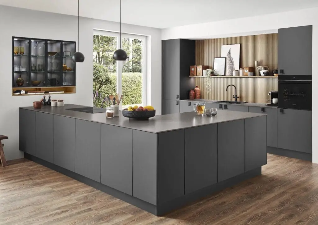 Kitchen suppliers inspiration: modern minimalist kitchen with matte gray flat-panel cabinets, large island, and integrated appliances.