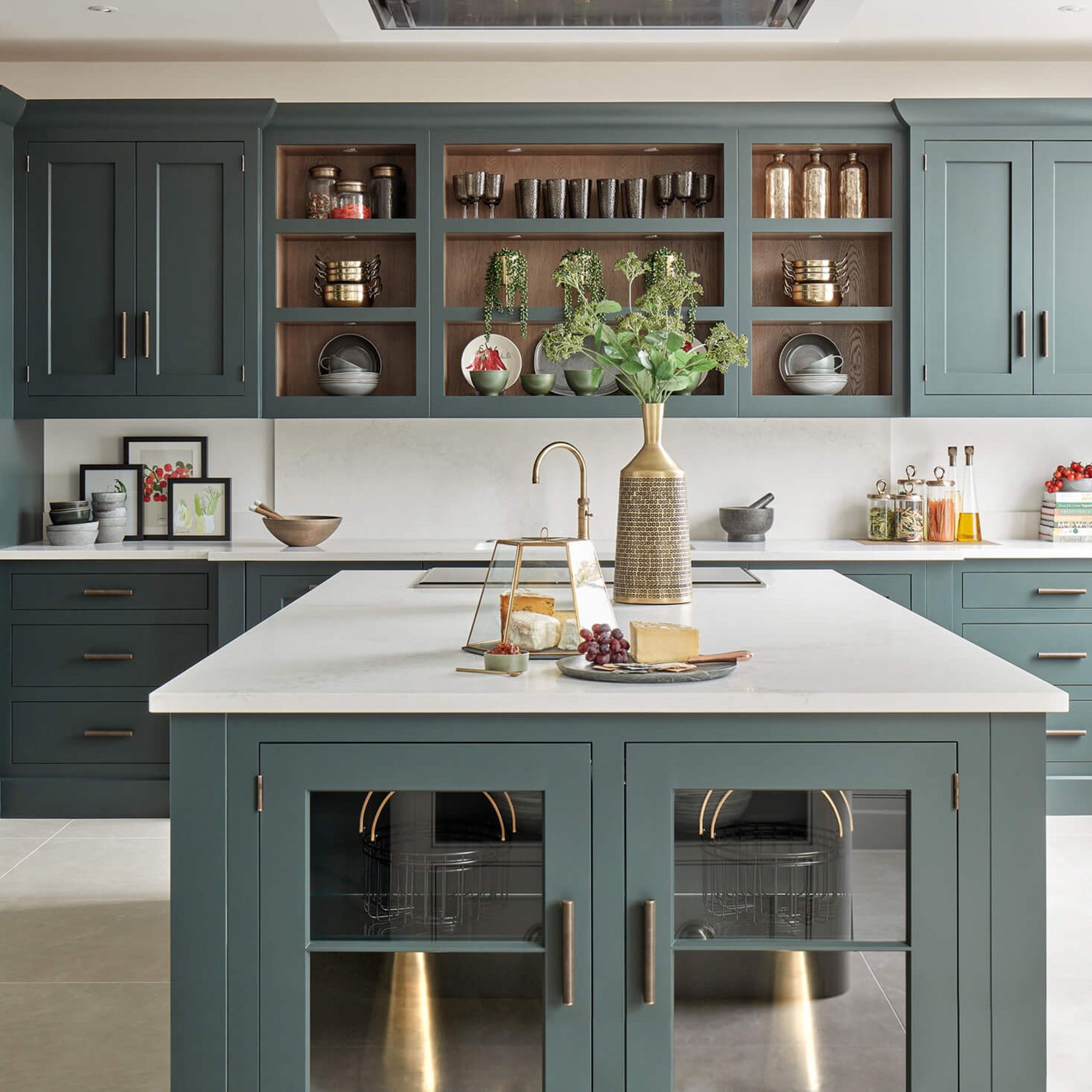 Modern teal kitchen with a large white island, brass hardware, and open wood shelves—low price kitchen cabinet style.