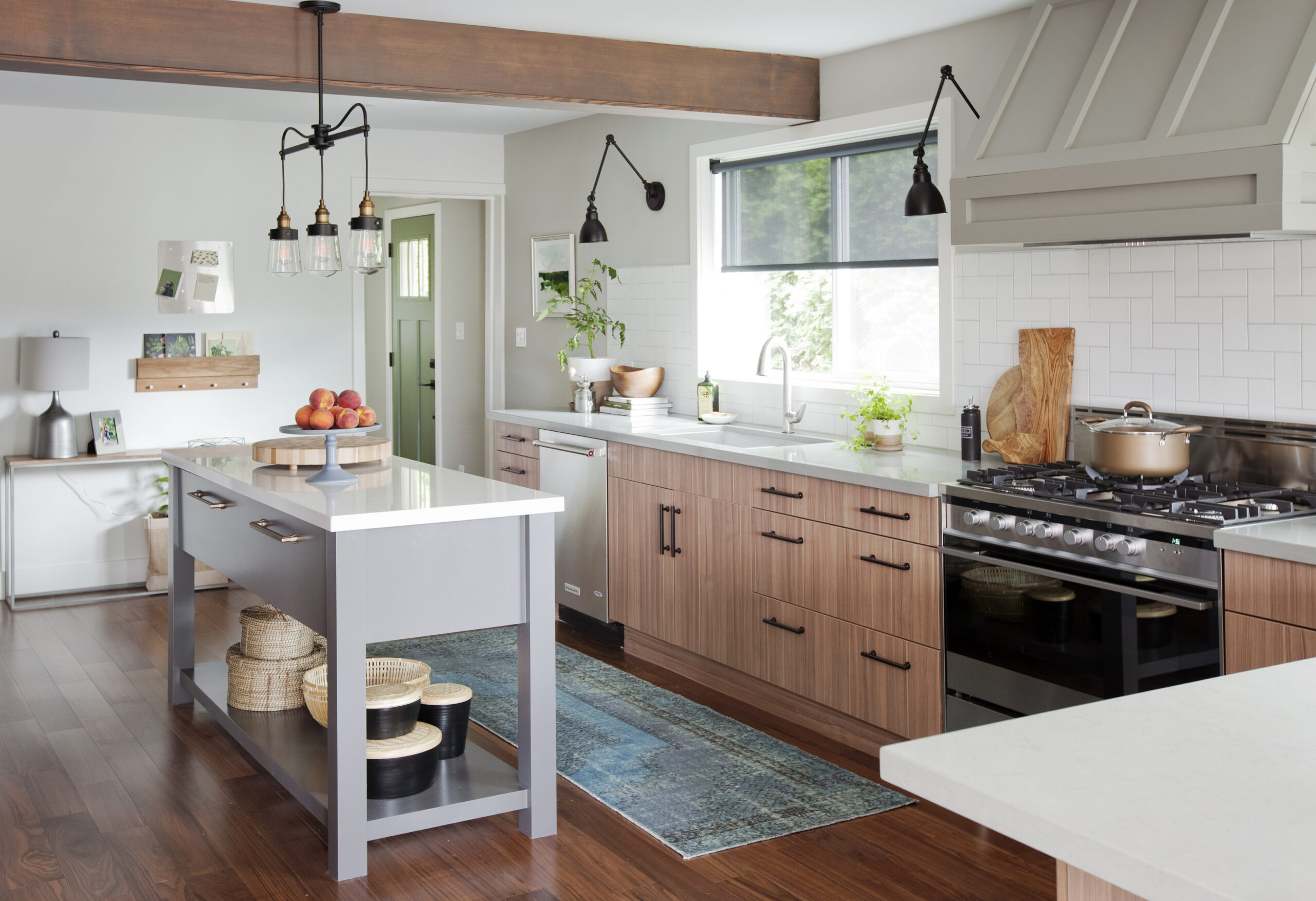 Modern kitchen with walnut wood drawers and white quartz counters, featuring a grey island and sleek premade kitchen cabinet storage with black hardware