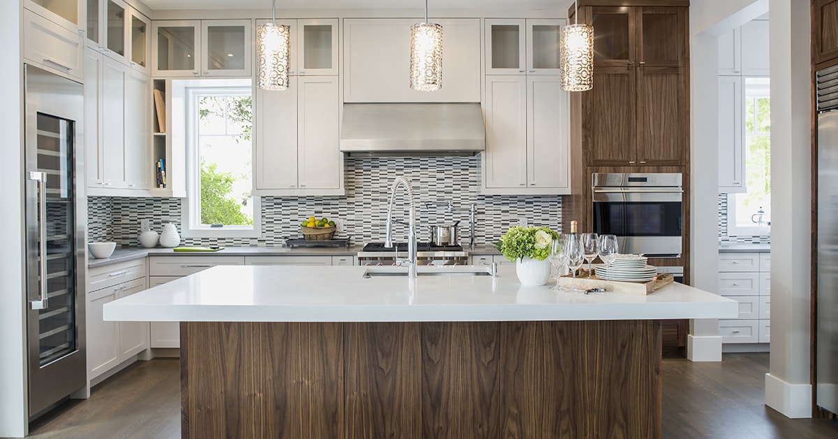 Modern kitchen with white shaker-style Premade kitchen cabinet units, a large walnut-toned island, mosaic tile backsplash, and pendant lighting.