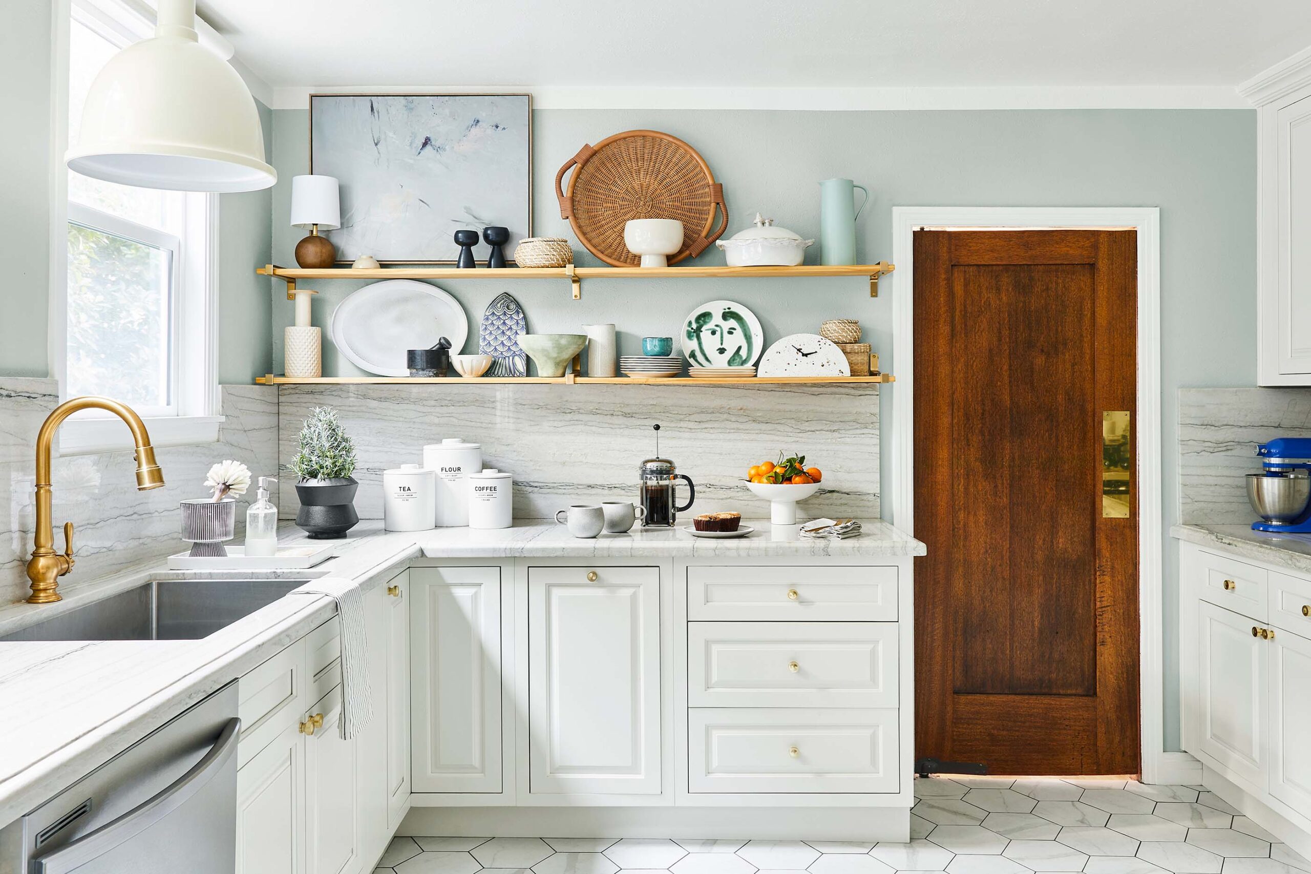 Bright white shaker-style kitchen with brass hardware, open wood shelves, marble-look backsplash, and a low price kitchen cabinet setup that looks custom.