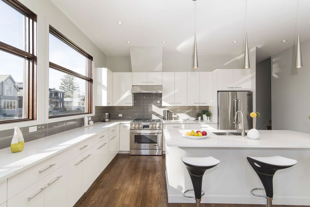 Modern kitchen cabinet design with matte black base cabinets and a white waterfall island in an open-concept luxury kitchen