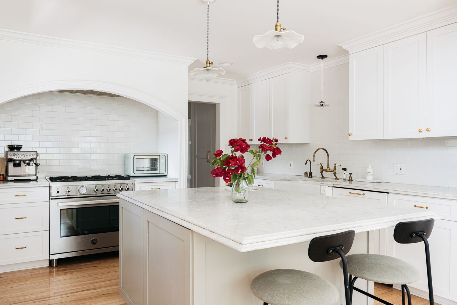Bright white shaker-style kitchen with a large marble-look island, brass hardware, and low price kitchen cabinet inspiration for a clean modern remodel.