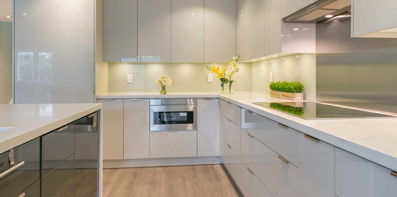 Modern minimalist kitchen with glossy flat-panel cabinets, quartz countertops, and under-cabinet lighting by trusted kitchen suppliers