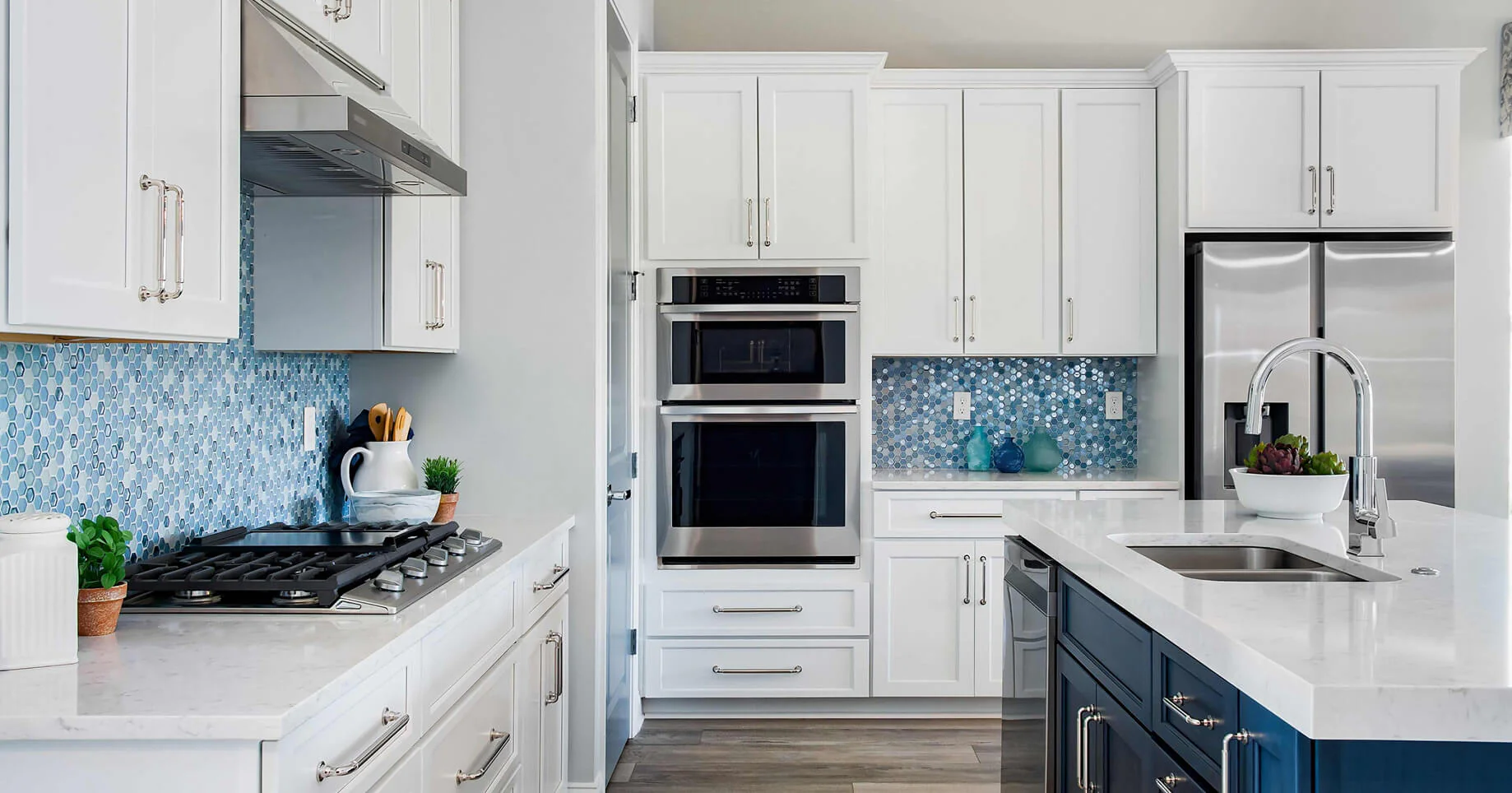 Modern kitchen with white shaker cabinets, blue mosaic backsplash, navy island, quartz countertops, and stainless appliances — Kitchen cabinet supplier in Canada.