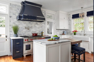 Modern kitchen cabinet Mississauga design featuring white shaker cabinets, a navy blue custom range hood, marble island countertop, and elegant transitional finishes.
