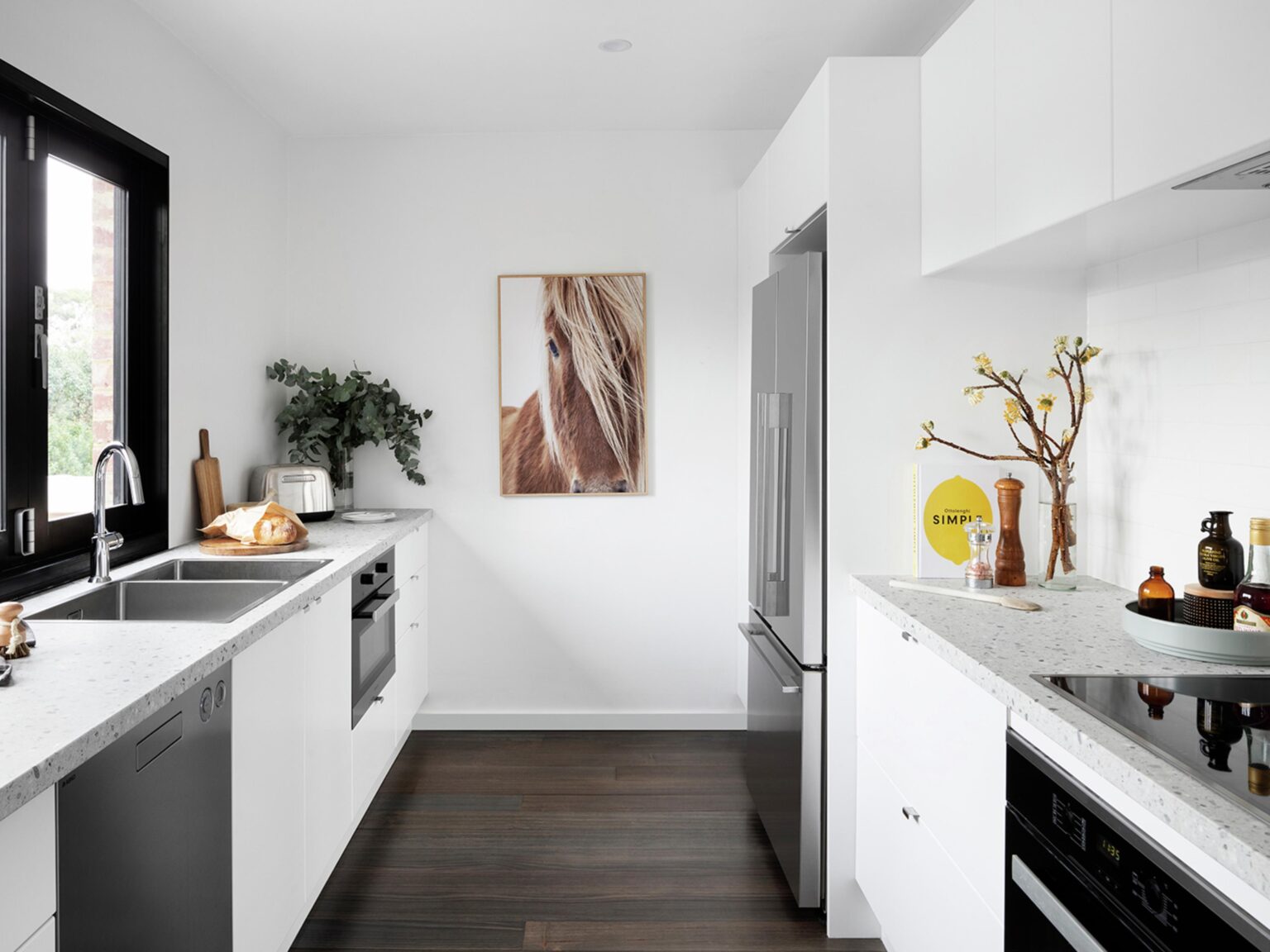 Modern white flat pack kitchen cabinet layout with quartz countertops, built-in appliances, and minimalist design in a bright contemporary home.