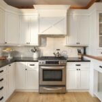 White shaker-style kitchen cabinet Mississauga design with quartz backsplash, stainless steel range, and custom hood for a bright modern home