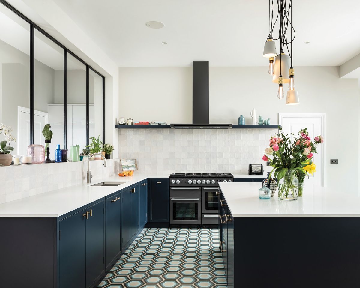 Modern U-shaped kitchen with navy Premade kitchen cabinet bases, white quartz countertops, patterned tile floor, and black range with minimalist hood.