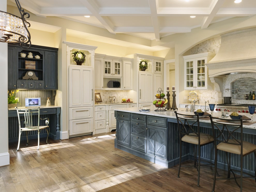 Low price kitchen cabinet style in a bright two-tone kitchen with white cabinetry, navy island, and bar seating.