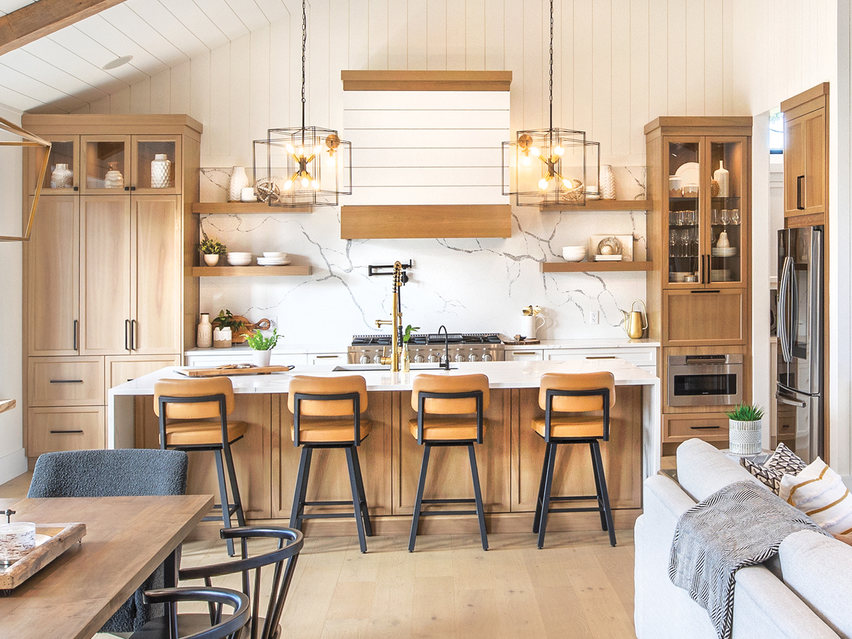 Modern Canadian kitchen with natural wood cabinets, white waterfall island, pendant lights, and marble-look backsplash from a kitchen cabinet supplier.