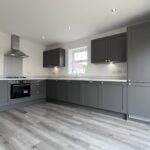 Kitchen Suppliers: modern dark grey shaker kitchen cabinets with tall pantry and white countertops