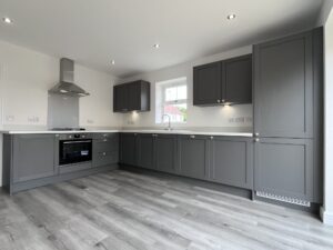 Kitchen Suppliers: modern dark grey shaker kitchen cabinets with tall pantry and white countertops