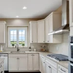 White shaker RTA kitchen cabinets with glass uppers, crown molding, and classic traditional design