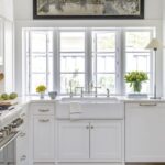 Bright white shaker-style kitchen with custom cabinetry, farmhouse sink, and modern hardware by a premium kitchen cabinet supplier