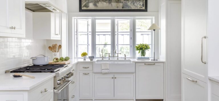Bright white shaker-style kitchen with custom cabinetry, farmhouse sink, and modern hardware by a premium kitchen cabinet supplier