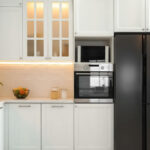Modern white shaker kitchen cabinets with glass uppers and black fridge – Kitchen cabinet Mississauga