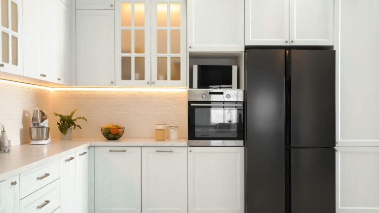 Low price kitchen cabinets in a bright modern white kitchen with a large island and quartz countertop