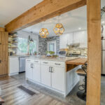 Low Price Kitchen Cabinet modern white shaker kitchen with large island, wood beam accents, and stainless steel appliances