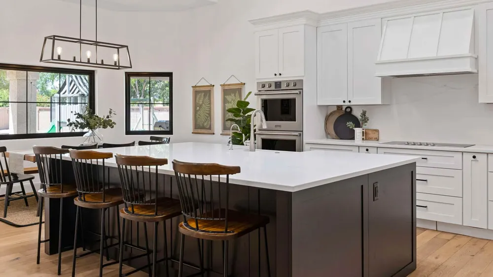 Modern white kitchen cabinet Mississauga design with large island, quartz countertop, and built-in appliances in a bright Canadian home