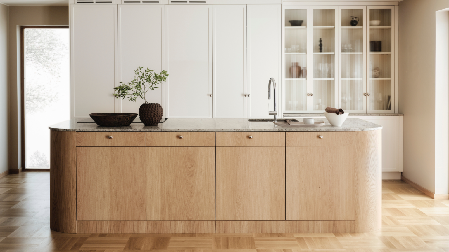 Modern minimalist kitchen by a kitchen cabinet supplier, featuring white built-in cabinets, a natural wood island, and a marble countertop with integrated sink.