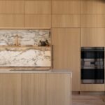 handleless light wood kitchen cabinets with slab doors and marble backsplash