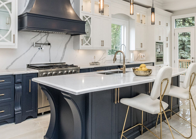 Modern kitchen cabinet Mississauga design featuring navy blue and white cabinets, a large quartz island, brass hardware, and an elegant open-concept layout.