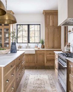 Natural oak shaker RTA kitchen cabinets with white countertops and a farmhouse sink in a bright Canadian kitchen